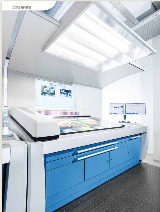 Printing press control station with a printed sheet under overhead lighting